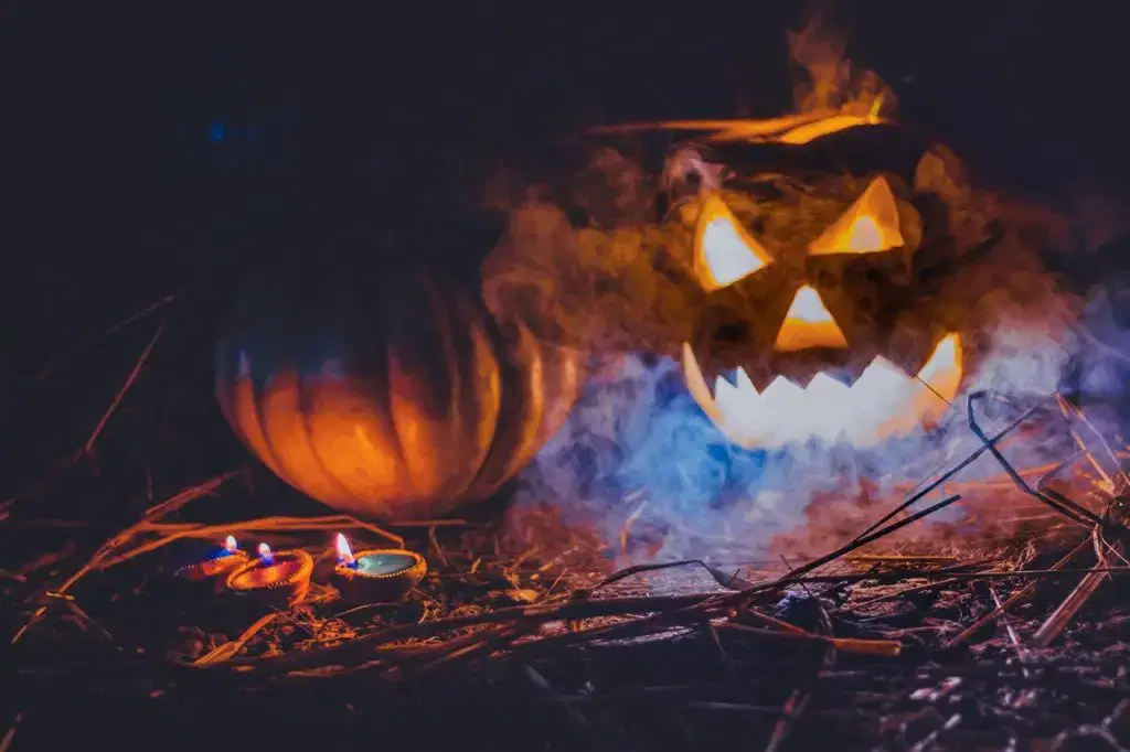 Two carved jack-o'-lantern pumpkins with festive Halloween decorations