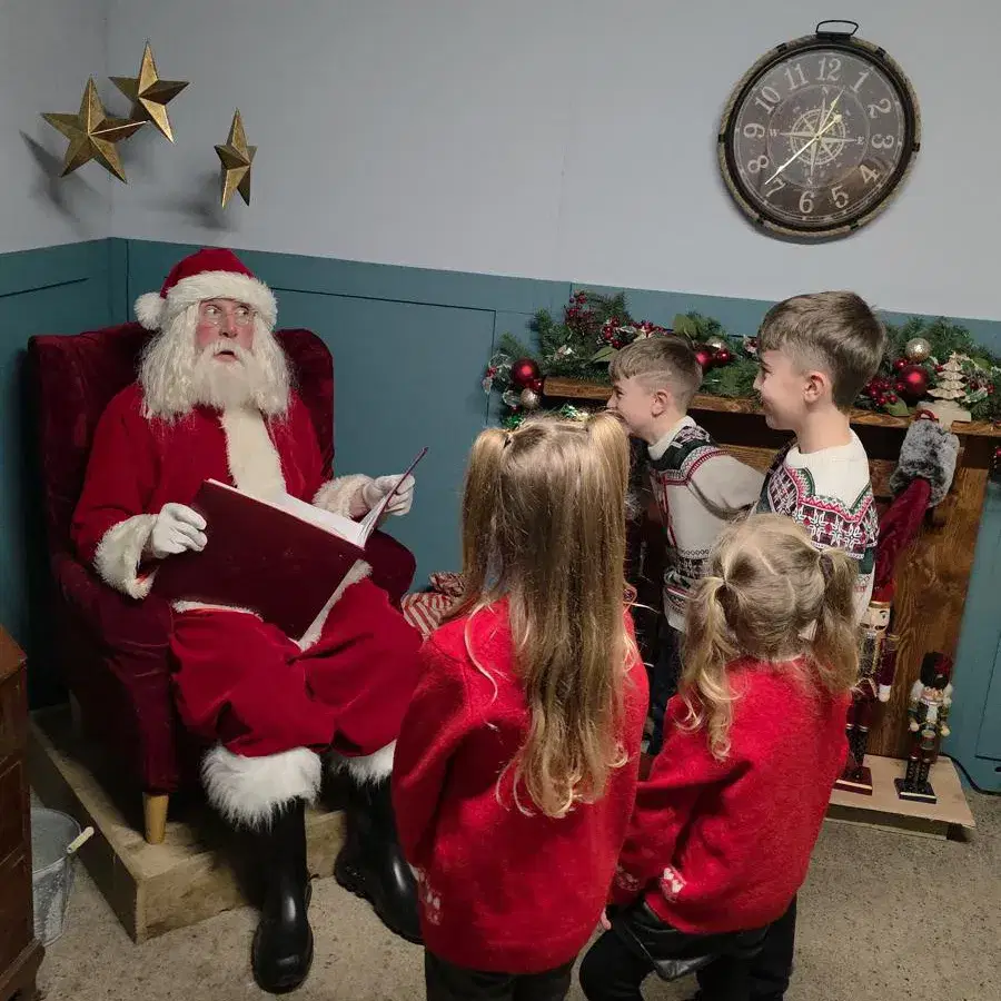 Santas Grotto Christmas Experience Santa and the young boy by the Christmas tree